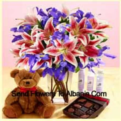 Lys roses et fleurs violettes assorties disposées magnifiquement dans un vase en verre, un mignon ourson brun de 12 pouces de hauteur et une boîte de chocolats importés