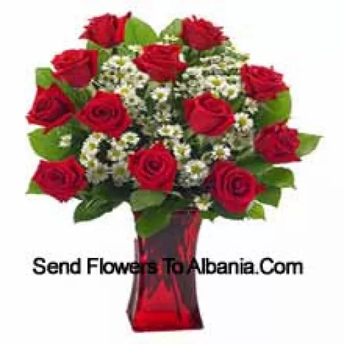 11 roses rouges avec quelques fougères dans un vase en verre
