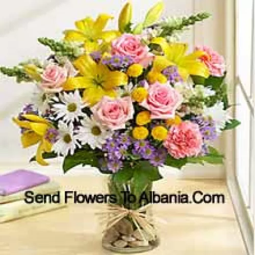 Roses roses, œillets roses, gerberas blancs et lis jaunes avec des remplissages saisonniers dans un vase en verre