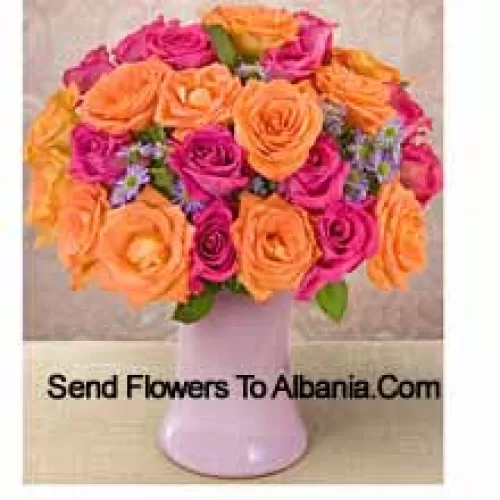 15 roses roses et 10 roses orange avec des garnitures de saison dans un vase en verre