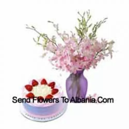 Des orchidées fraîches dans un vase accompagnées d'un gâteau aux fraises de 1/2 kg