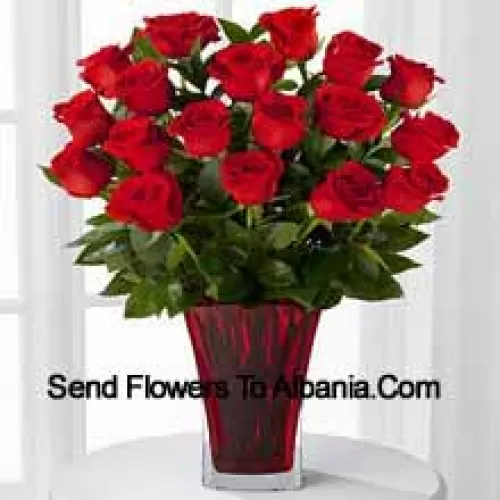 19 roses rouges avec des remplissages saisonniers dans un vase en verre décoré d'un nœud rose